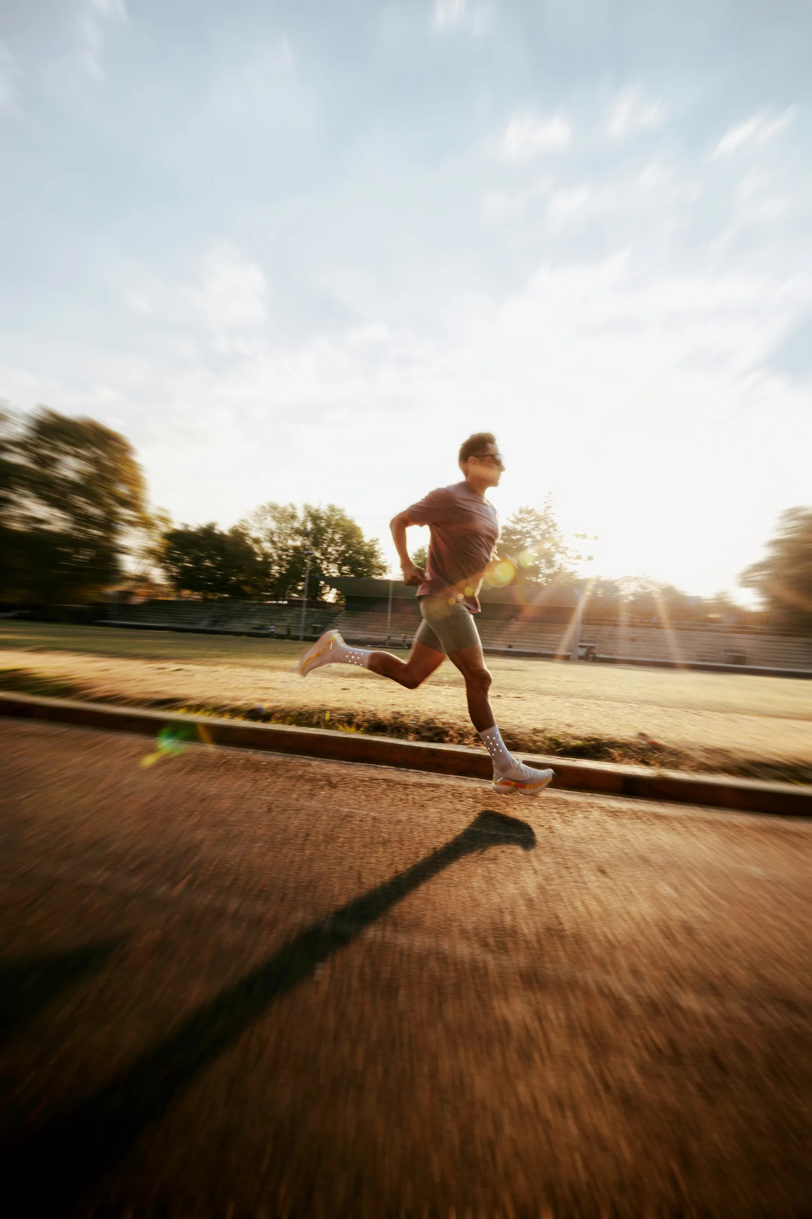 Man running on a track at sunrise
